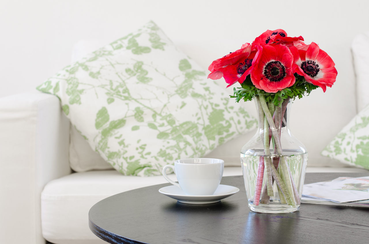 vase-of-red-flowers-in-modern-white-living-room
